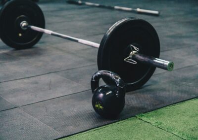 Barbell and kettlebell on gym floor, ideal for fitness and strength training themes.